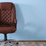 Ember ül ergonomikus irodai széken, fenntartva helyes testtartást és hátsó támaszt.